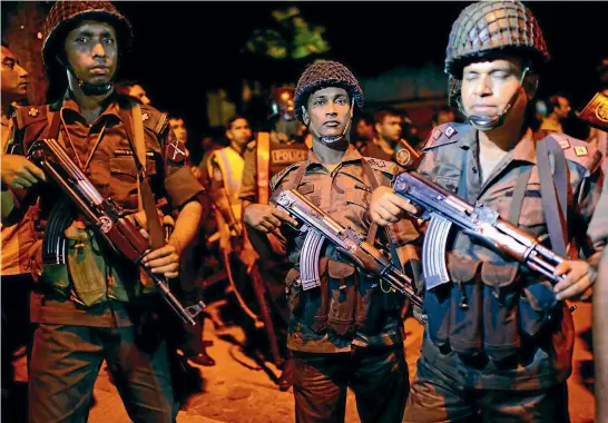  ?? GETTY IMAGES ?? Bangladesh­i soldiers prepare to storm the Holey Artisan restaurant in the capital, Dhaka, to rescue hostages held by Islamic State gunmen.