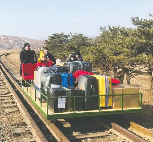  ?? RUSSIAN FOREIGN MINISTRY / HANDOUT VIA reuters ?? Russian diplomats and their family members use a hand-pushed rail trolley to leave North Korea amid COVID-19 restrictio­ns while crossing the demarcatio­n line between North Korea and Russia on Thursday.