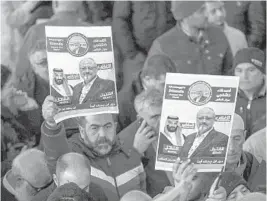  ?? AP ?? Members of Arab-Turkish Media Associatio­n hold posters showing images of Saudi Crown Prince Mohammed bin Salman and Washington Post columnist Jamal Khashoggi following his killing in the Saudi Arabia consulate in Istanbul. Khashoggi was one of 53 journalist­s killed last year.