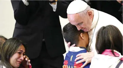  ??  ?? THE VATICAN: Pope Francis hugs a boy during an audience with Huntington’s disease sufferers and their families, in the Paul VI Hall, at the Vatican. — AFP