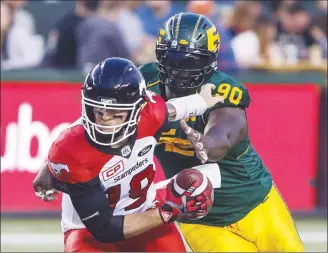  ?? Canadian Press photo ?? Calgary Stampeders quarterbac­k Bo Levi Mitchell (19) gets sacked by Edmonton Eskimos' Almondo Sewell (90) during first half CFL action in Edmonton during a game in September.