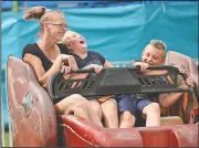  ?? AP/The Herald-Palladium/DON CAMPBELL ?? April Lugo (from left), Asia Lugo, 8, and Duane McLaughlin, 8, of Berrien Springs, Mich., take a spin Tuesday on the Sizzler at the Berrien County Youth Fair.