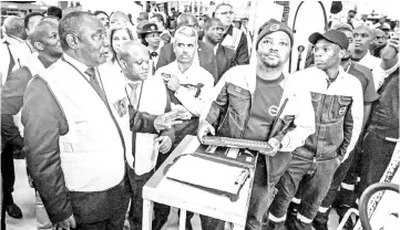  ??  ?? Ramaphosa (left) interacts with workers during a visit to the Volvo Automobile factory plant in Durban. — AFP photo