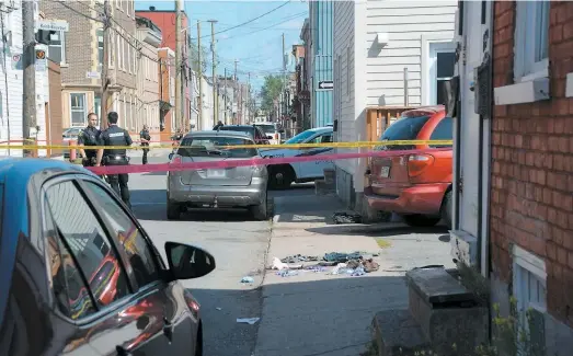  ?? PHOTO AGENCE QMI, GUY MARTEL ?? La police enquête après la découverte d’un homme gisant blessé devant le 607 de la rue Napoléon, dans Saint-sauveur.