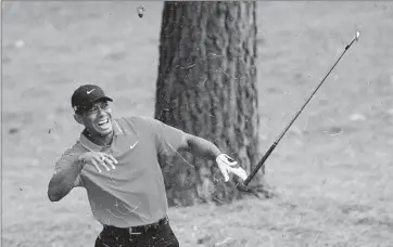  ?? David Cannon
Getty Images ?? AFTER A SHOT from pine straw on the ninth hole, Tiger Woods reacts to hitting a tree root. “A bone kind of popped out. And the joint kind of went out of place. But I put it back in,” he said of his wrist.