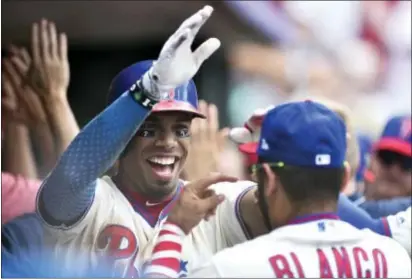  ?? DERIK HAMILTON — THE ASSOCIATED PRESS ?? The Phillies’ Nick Williams, left, high fives Andres Blanco in the dugout after Williams hit a two-run home run off the Brewers’ Junior Guerra during the fourth inning Sunday in Philadelph­ia.