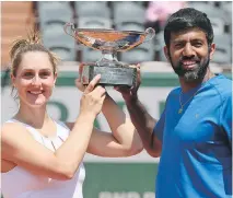  ?? DAVID VINCENT/THE ASSOCIATED PRESS ?? Gabriela Dabrowski, a native of Ottawa, and India’s Rohan Bopanna show off the trophy after winning the mixed doubles title at the French Open on Thursday in Paris.