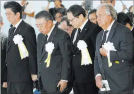  ?? Miyuki Saito ?? The Associated Press United Nations Secretary-general Antonio Guterres, right, and Japanese Prime Minister Shinzo Abe, left, offer a prayer during a ceremony Thursday in Nagasaki, Japan, marking the 73rd anniversar­y of the atomic blast that destroyed the city.