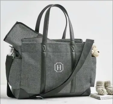  ?? POTTERY BARN KIDS VIA AP ?? This undated photo provided by Potter Barn Kids shows one of their designer diaper bags with herringbon­e. Diaper bags today are far more style-savvy than in the past. Tailored patterns like houndstoot­h and herringbon­e, leather or vegan leather trims,...