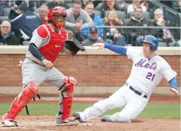  ?? AP ?? The Mets’ Todd Frazier slides home ahead of the throw to Cardinals catcher Yadier Molina in the fifth inning Thursday.