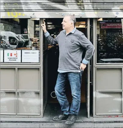  ?? XAVIER CERVERA ?? El propietari­o de un bar de Barcelona, a punto de bajar la persiana ayer