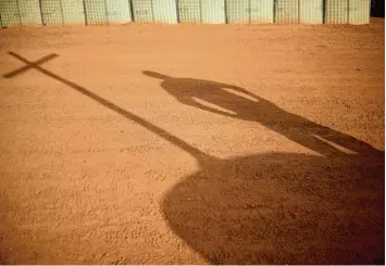  ?? Foto: Britta Pedersen, dpa ?? Der Schatten eines Kreuzes fällt auf den roten Sand im Camp Castor in Gao, im afrikanisc­hen Mali. Das ZDF begleitete einen Sol daten ein Jahr lang bei der UN Mission „Minusma“.