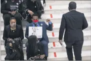  ?? BEN GRAY — THE ASSOCIATED PRESS ?? Protesters opposed to changes in Georgia’s voting laws sit on the steps inside the State Capitol in Atlanta, Ga., as the Legislatur­e meets Monday, in Atlanta.