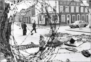  ?? AFP ?? A little girl is seen in a street of the Belfast Catholic area, looking at barbed wire near a road-block, on June 29, 1974.