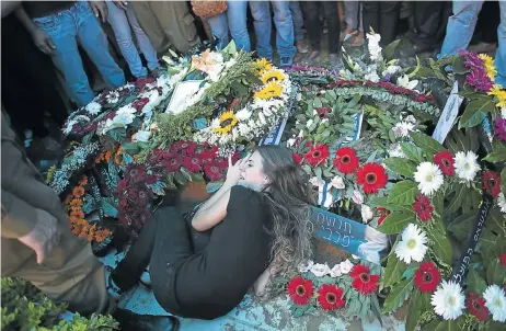  ?? Picture: REUTERS ?? CYCLE OF VIOLENCE: The girlfriend of Israeli soldier Tal Yifrah, killed in the military offensive against Hamas in Gaza, mourns as she lies atop his grave during his funeral in Rishon Lezion near Tel Aviv on July 22