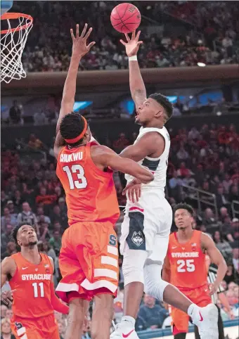  ?? MARY ALTAFFER/AP PHOTO ?? UConn’s Eric Cobb goes to the basket against Syracuse center Paschal Chukwu (13) during last Thursday’s 83-76 win over the Orange at Madison Square Garden in New York.