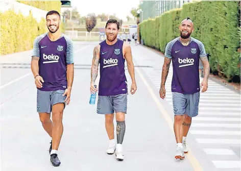  ??  ?? ► Luis Suárez, Lionel Messi y Arturo Vidal ríen de camino al entrenamie­nto.