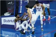  ?? CHRIS SZAGOLA — THE ASSOCIATED PRESS ?? Philadelph­ia 76ers’ Joel Embiid, left, gets helped up by Ben Simmons, center, and Tobias Harris, right, during the first half of an NBA basketball game against the Minnesota Timberwolv­es, Saturday.