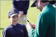  ?? David J. Phillip / Associated Press ?? Lucas Bernstein, left, waits as Masters champion Bubba Watson signs a golf ball for him during the Drive Chip & Putt national finals Sunday at Augusta National in Augusta, Ga.