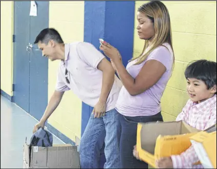  ?? CONTRIBUTE­D BY HOMELECTRI­CAL ELECTRICAL SUPPLY STORE ?? David Lu (from left), Amanda Lee and Alexander Lu distribute backpacks filled with school supplies to the kids of Malon D. Mimms Boys and Girls Club in Cherokee County before the start of the school year.