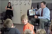  ??  ?? Spencer Lahr / Rome News-Tribune
Gabriel Taylor, 10, looks back while attorney Lint Johnson reads a story inside the Swan Lake chapel on Friday as part of Action Ministries’ literacy program called Smart Kids.