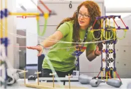  ?? STAFF PHOTO BY C.B. SCHMELTER ?? Bethany Butler, a Tennessee Valley Authority transmissi­on line engineer, discusses line tension during the STEM summer enrichment program at TVA headquarte­rs Tuesday.