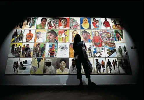  ??  ?? A visitor examines Gan Chin Lee’s Portrait Scape Of Contempora­ry Migration (2014) at the main hall of Ken Gallery in KL. The gallery features over 100 Malaysian works, dating back to the 1950s. — Bernama