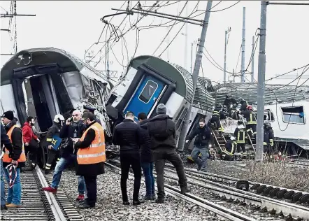  ?? — AP ?? Rail tragedy: Rescue teams helping passenger out of a derailed train at the station of Pioltello Limito, on the outskirts of Milan.