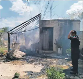  ?? ?? Un policía de Tizimín observa lo que quedó de una vivienda que fue consumida por el fuego anteayer