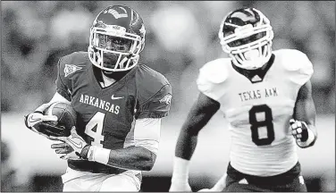  ?? Arkansas Democrat-Gazette file photo ?? Arkansas receiver Jarius Wright (left) outruns Texas A&M linebacker Garrick Williams to the end zone during the first quarter. Wright caught 11 passes for 281 yards and two touchdowns for the Razorbacks, who outscored the Aggies 25-3 in the second half...
