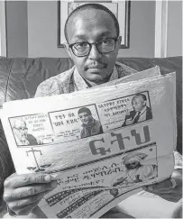  ?? BRANDON HARDER
POSTMEDIA NEWS ?? Journalist Mastewal Birhanu sits in the living room of his Regina home. Birhanu worked for an Ethiopian newspaper called Feteh, an issue of which he is holding, focusing on exposing human rights issues and government corruption.
•