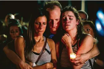  ?? Charlie Riedel / Associated Press ?? From left, Mallory Cunningham, Santino Tomasetti and Aubrey Reece attend a candleligh­t vigil in the parking lot of Ride the Ducks on Friday in Branson, Mo., a tourist destinatio­n for theMidwest.