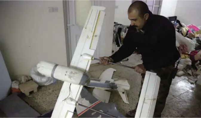  ??  ?? MOSUL: An Iraqi officer inspects drones belonging to Islamic State militants in Mosul, Iraq. — AP