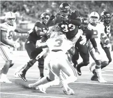  ?? Michael Ainsworth/Associated Press ?? ■ TCU running back Sewo Olonilua (33) scores a touchdown as Ohio State’s Damon Arnette Jr. attempts to take him down during the first half of an NCAA football game Saturday in Arlington, Texas.