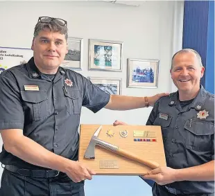  ?? ?? Presentati­on Current group commander Vincent O’Donnell, left, presented a gift to Ewan Baird on behalf of all his former colleagues