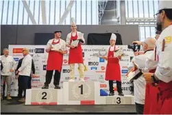  ?? - AFP photos ?? Winner Dimitri Bordon of France stands on the podium following the “pain au chocolat” also known as a “chocolatin­e” in south-west France, annual Coupe du Monde (World Cup) de la Chocolatin­e competitio­n, in Toulouse.