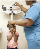  ??  ?? CHICAGO: In this Wednesday, Dec 16, 2015, photo, Emaurie Walker, 4, has her height and weight checked during a physical test at an Erie Family Health Center clinic. — AP
