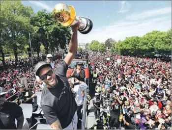  ?? Frank Gunn Associated Press ?? KAWHI LEONARD raises his Finals MVP trophy before thousands of Toronto Raptors fans in June. Leonard will return to play in Canada tonight for the first time since signing with the Clippers.