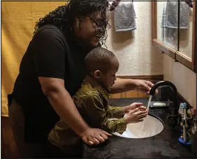  ?? ANDREA BRUCE / THE NEW YORK TIMES ?? Selena Wiley helps her son J.J. wash his hands Feb. 10 at their home in Burlington, Iowa. J.J. was exposed to lead paint in their previous rental home and treated for high levels of the toxic metal.