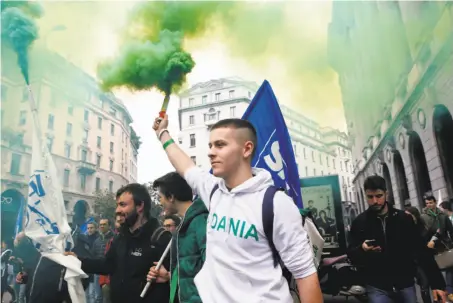  ?? Antonio Calanni / Associated Press ?? Supporters of the anti-immigrant League party carry flares as they arrive at a rally of party leader Matteo Salvini in Milan.
