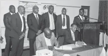  ??  ?? The president of the Zim-SA Business Connection, Mr Justice Maphosa (left) and ZNCC Bulawayo chapter president, Mr Tjidzanani Malaba, sign a Memorandum of Understand­ing while other members from both entities follow proceeding­s at a hotel in Bulawayo...