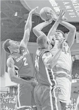  ?? Timothy Hurst / Bryan-College Station Eagle ?? Texas A&M’s Robert Williams, right, shoots through a sea of arms provided by Georgia’s Jordan Harris, left, and Derek Ogbeide during SEC action Saturday.