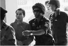  ??  ?? Oeuth Ang (second left) is escorted by police personnel upon his arrival at Phnom Penh municipal court. — AFP photo