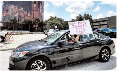  ?? JOE BURBANK/ORLANDO SENTINEL ?? A Florida teacher holds up a protest sign during a car parade earlier this month outside an administra­tion center in downtown Orlando.