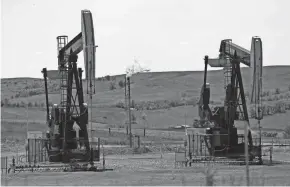  ?? CHARLES REX ARBOGAST/AP FILE ?? Oil pumps and natural gas burn off in Watford City, North Dakota, in June 2014. The U.S. Senate has sent a bill to the House that would restore the Environmen­tal Agency’s ability to regulate methane emissions from such operations.