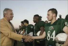  ?? TSAFRIR ABAYOV — THE ASSOCIATED PRESS ?? In this Thursday photo, former NFL player Joe Montana shakes hands with an Israeli football player in Ramat Hasharon, near Tel Aviv, Israel. 18 members of the Pro Football Hall of Fame who arrived for a weeklong visit to meet some of the 2,000 active...
