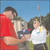  ??  ?? American Legion Post 22’s Bill Selling presents the flag used during the ceremony to Jeremy Coe, grandson of Arthur Coe, who was instrument­al in the installati­on of the first flagpole at the park, after the dedication ceremony.