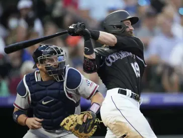  ?? David Zalubowski, The Associated Press ?? Colorado‘s Charlie Blackmon follows the flight of his two-run home run with Braves catcher Stephen Vogt, left, in the third inning of a baseball game on Saturday at Coors Field.