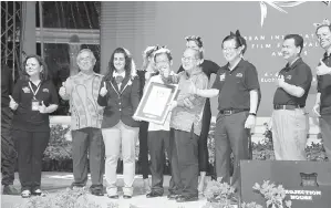  ??  ?? UGGAH (tiga kanan) menerima sijil Rekod Dunia Guinness daripada Hoda (tiga kiri) .