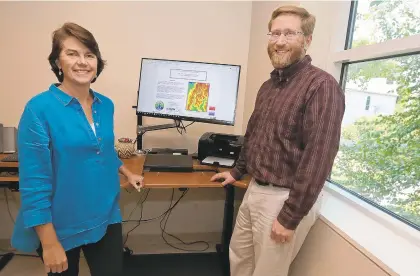  ?? JUDITH LOWERY/DAILY PRESS ?? Lisa Kellogg, left, senior research scientist, and Mark Brush, a Virginia Institute of Marine Science associate professor, have developed an online tool to assess the effects of oyster restoratio­n on waterways. The screen behind them shows the Harris Creek oyster restoratio­n model.